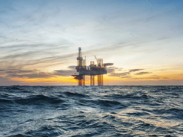 Jack-up rig on the horizon at sunset