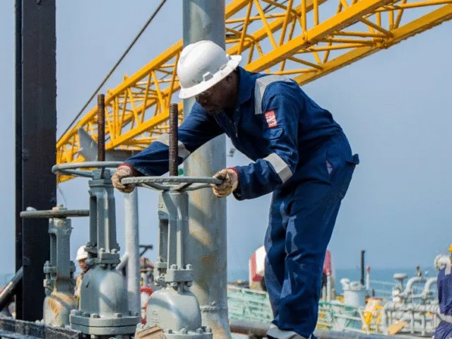 Worker operating a valve handwheel